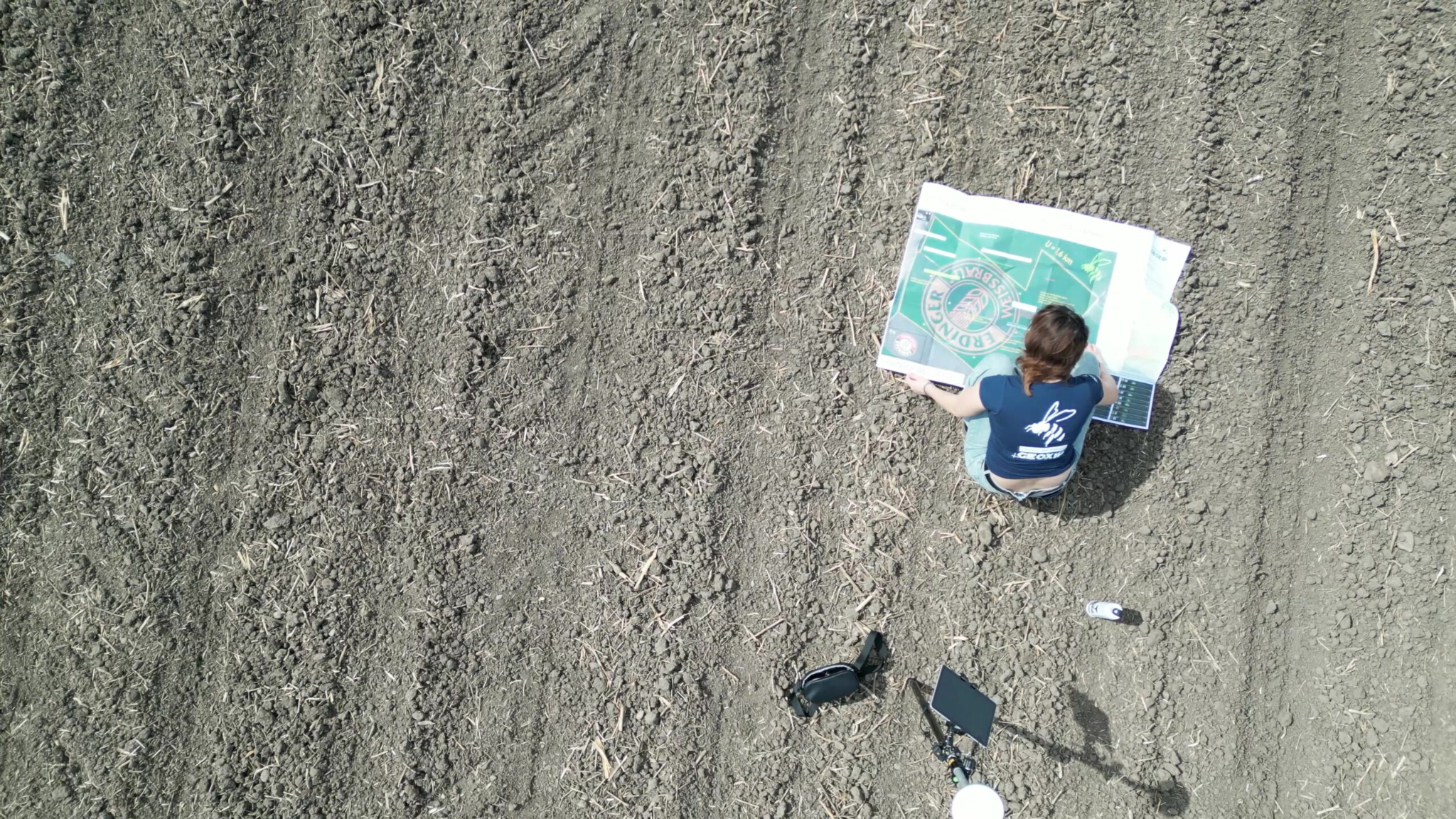 Planung einer GEOXIP Ackerwerbung direkt auf dem Acker: großformatiger Feldplan, Vermessung und Vorbereitung eines Bodenbildes für präzise GPS-gestützte Aussaat und Geobranding